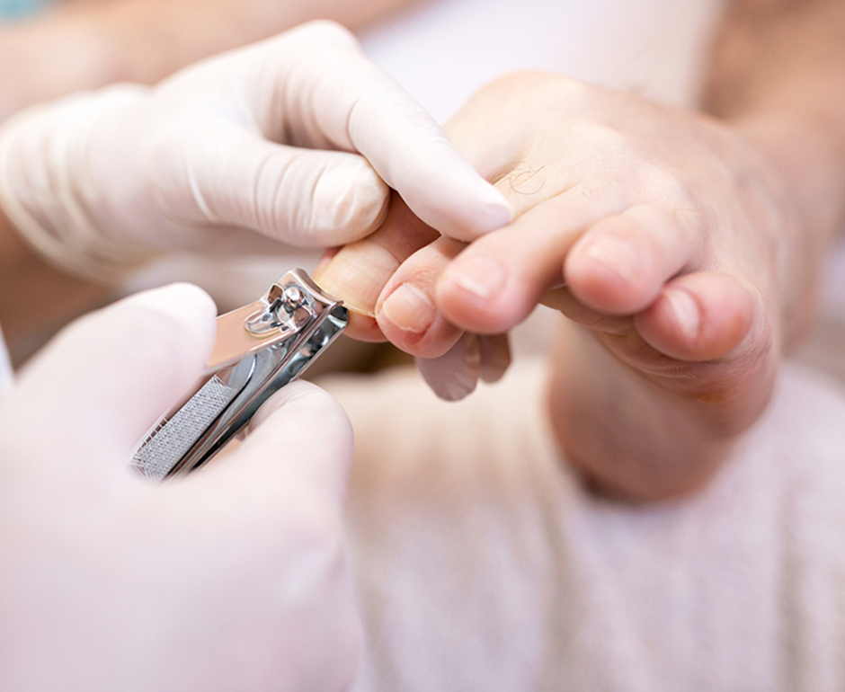 Foot care practitioner using nail clippers on toenails